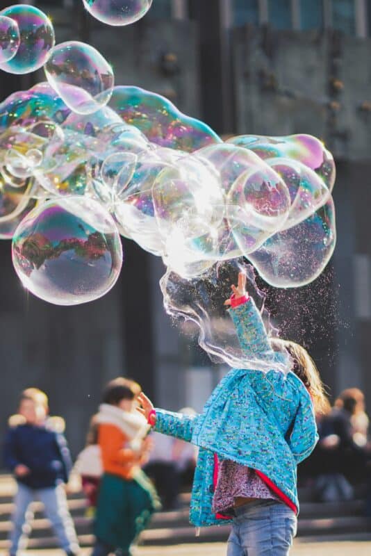 Ein Kind spielt mit einer Riesen-Seifenblase